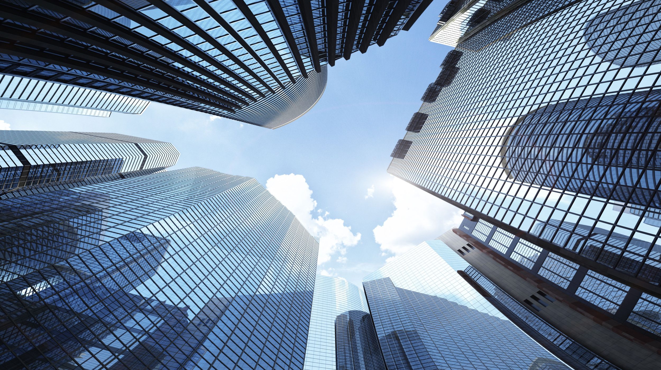 Low-angle view of glass skyscrapers reflecting the sky, symbolizing corporate environments and risk assessments.